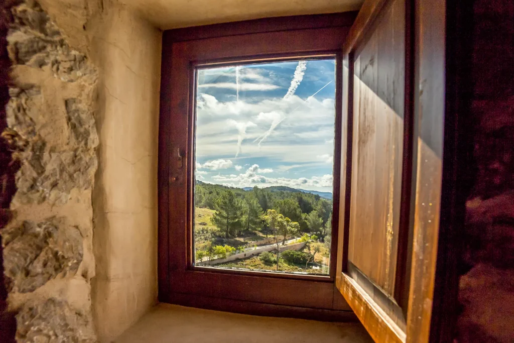 Vista a través de una ventana de una de las habitaciones dobles en el hotel rural Can Pujolet